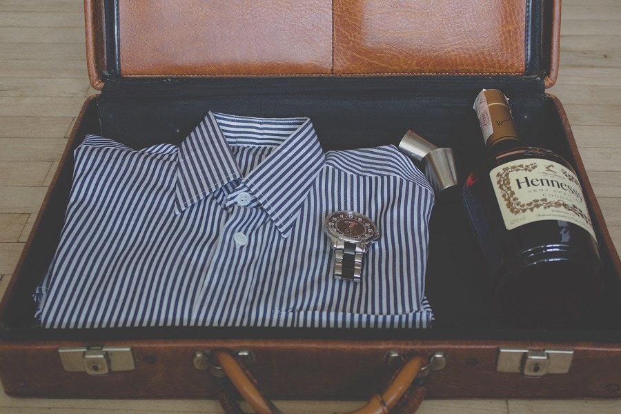 Suitcase with shirt and bottle of cognac